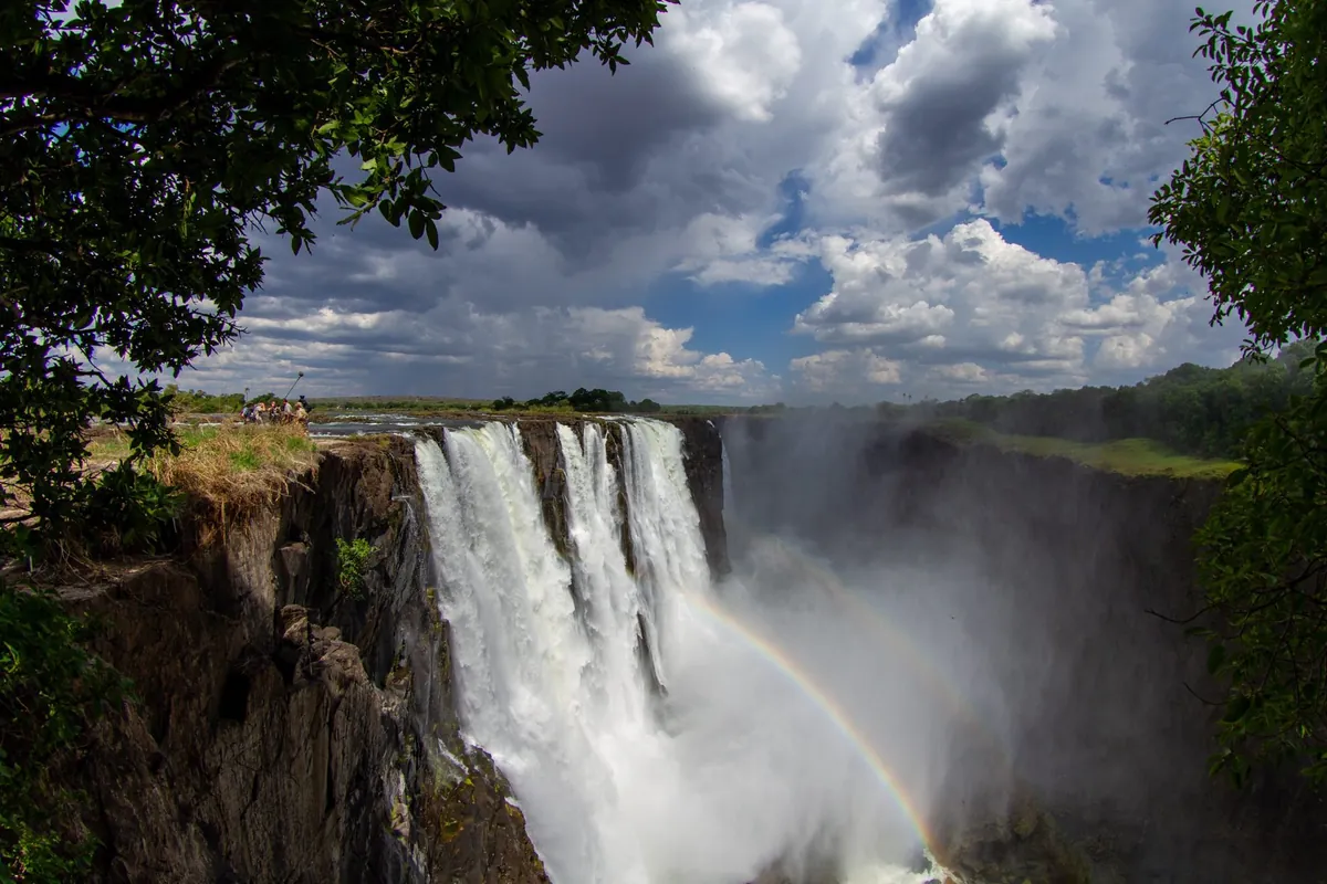 Victoria Falls with a full rainbow across the gorge