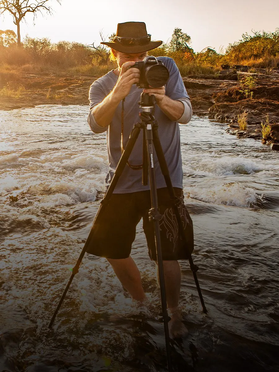 Tom Varley with a tripod on the lip of Victoria Falls